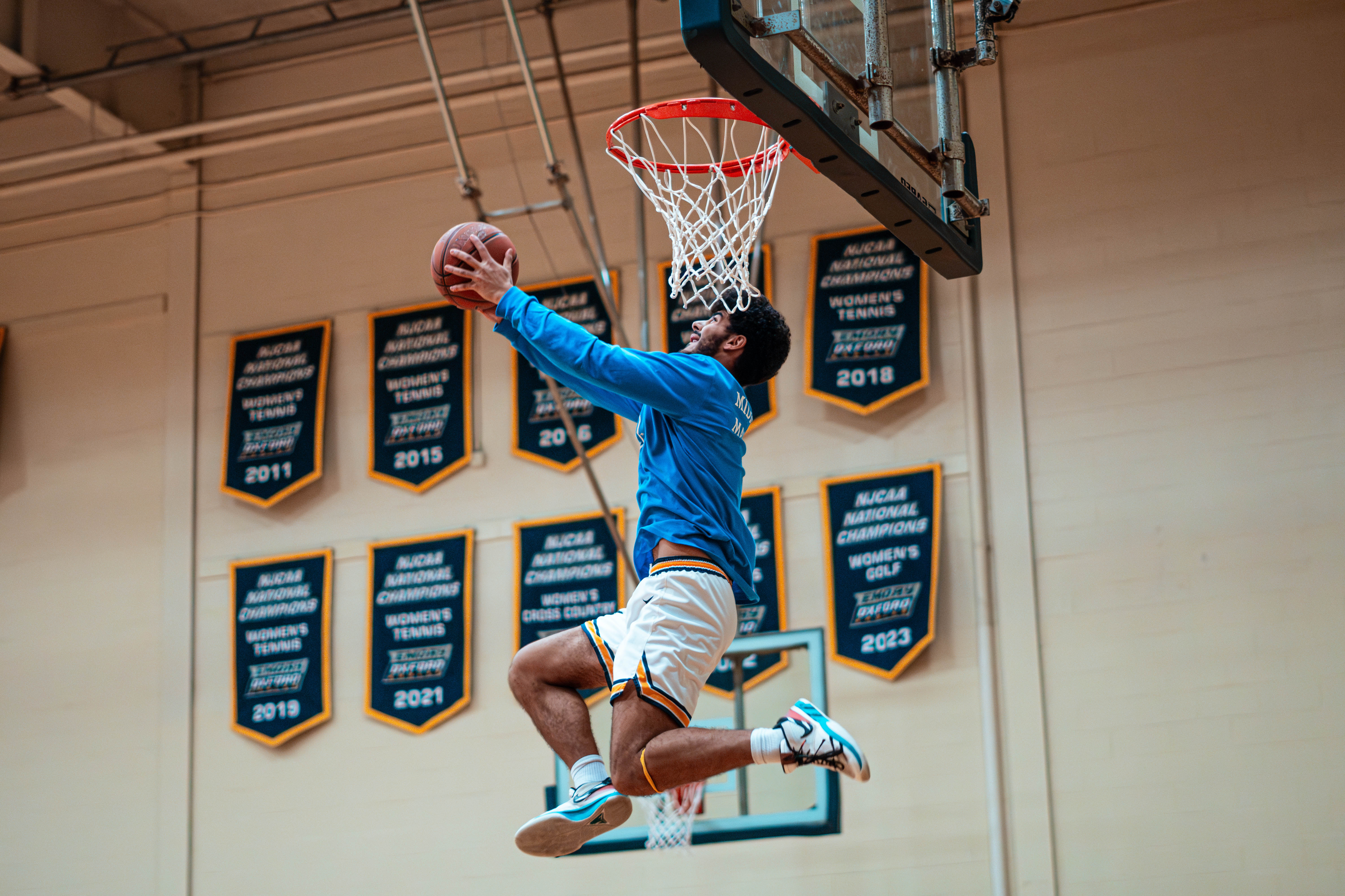 Oxford College basketball player attempts to dunk a basketball.