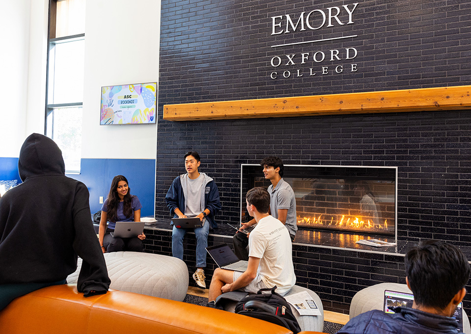students gather around a fireplace