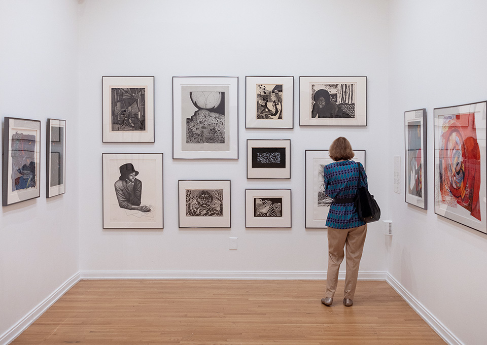 a person looks at artwork in the Carlos Museum