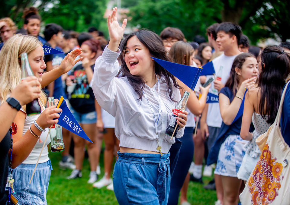 student waving in a crowd