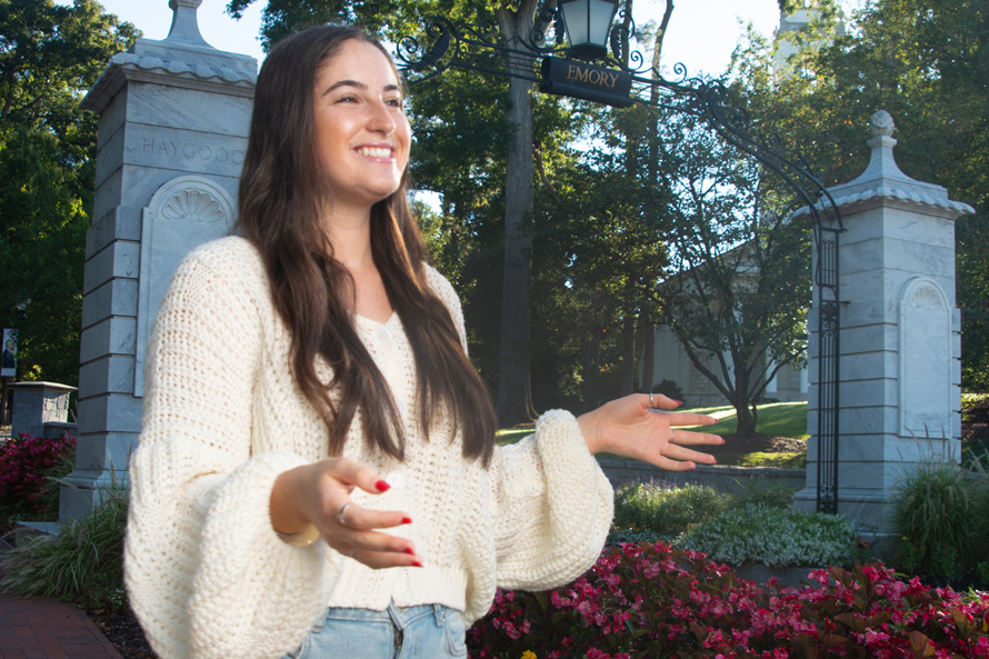 student Maya Fleischer 24C stands in front of the Haygood-Hopkins Gate on the Atlanta campus